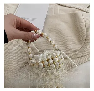 Close-up of pearl beaded bucket bag for girls with drawstring silk lining and gold beads