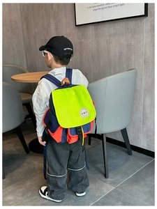 Detail of color-block kids backpack showing neon yellow flap and blue nylon fabric
