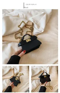 Dettaglio della mini borsa in pelle nera con catena dorata e chiusura quadrata in metallo