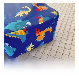 Close-up of durable navy fabric featuring colorful cartoon dinosaur prints and ROAR text