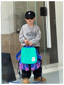 Detail of color-block canvas kids backpack with pockets worn by a stylish child