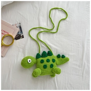 Detail of handmade crochet green dinosaur bag for kids with sharp 3D spikes and soft texture