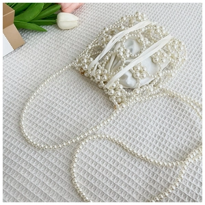 Détail du sac à main en perles tissées avec doublure en satin et chaîne élégante