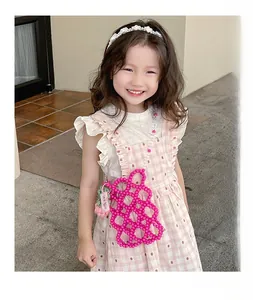 Pink handmade beaded crossbody bag for girls with pearl strap shown on a child model