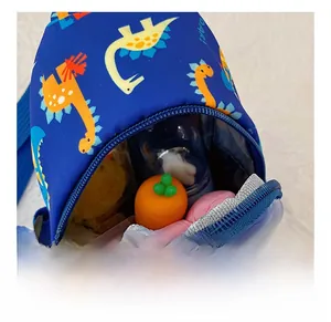 Detail view of the blue cartoon dinosaur chest bag showing interior storage capacity