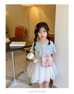 Détail d'un mini sac en tweed rose avec nœud satiné et poignée perle pour fille