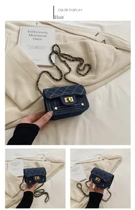 Dettaglio mini borsa in denim blu trapuntato con catena dorata e chiusura a scatto