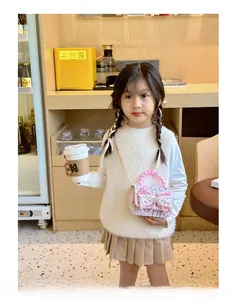 Dettaglio borsa in tweed rosa per bambina con grande fiocco in pizzo e manico di perle