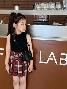 Detail of a chic British style girls' plaid pleated skirt and mini crossbody bag set