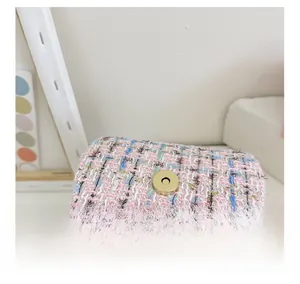 Détail de la texture en tweed rose et bleu et du fermoir magnétique doré