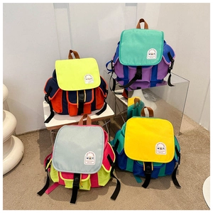 Detail view of four colorful patchwork canvas backpacks for kids in various bright combinations