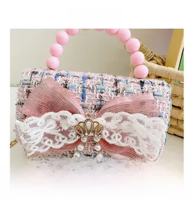 Dettaglio della borsa in tweed rosa e blu per bambina con fiocco e corona dorata
