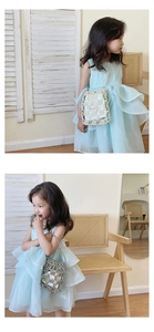 Détail de robe de fille en tulle bleu clair avec un sac à main luxueux en perles