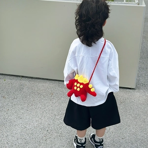 Handmade red crochet dinosaur crossbody bag with yellow fins and braided strap for kids