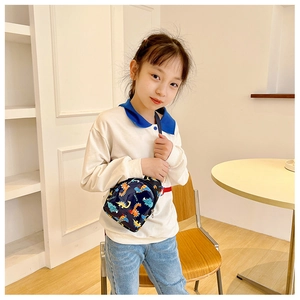 Close-up of kids crossbody bag featuring colorful cartoon dinosaur prints and sturdy zippers