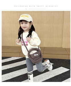 Close-up of brown chunky knit crossbody bag for kids styled with heart print sweatshirt