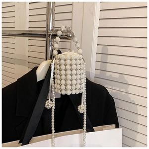 Detail shot of a handmade pearl woven bucket bag with drawstring liner and handle
