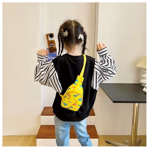 Close-up of yellow canvas kids chest bag featuring colorful cartoon dinosaur patterns