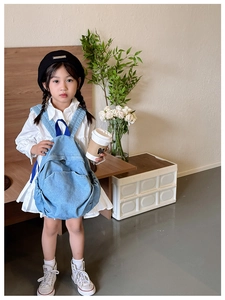 Kid modeling the lightweight light blue denim backpack with dark blue nylon straps