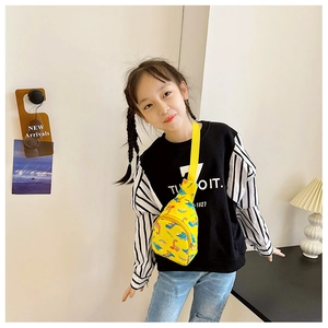 Detail of yellow canvas kids chest bag featuring colorful cartoon dinosaur prints