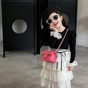 Completo moda bambina con top nero a sbuffo, gonna a balze bianca e borsa rosa trapuntata