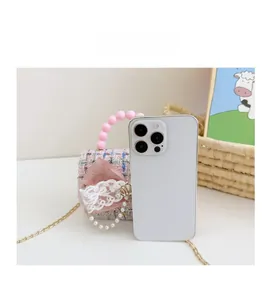 Mini borsa in tweed rosa per bambina con fiocco in pizzo rispetto a uno smartphone