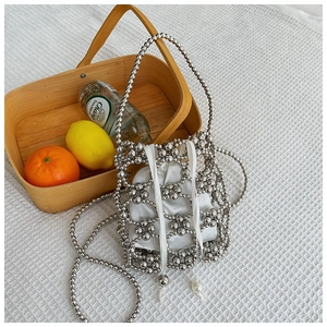 Sac seau perlé argenté avec tissage floral, doublure en satin et double bandoulière