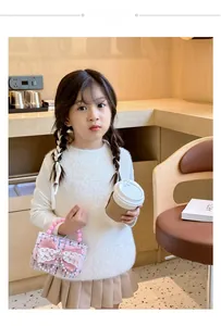 Bambina con borsa in tweed rosa con fiocco in pizzo e manico di perle alla moda