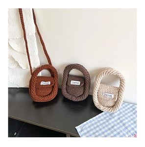 Macro shot of hand-knitted mini bags in caramel and cream colors showing texture