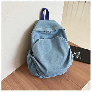 Detail of light blue denim kids backpack with durable zippers and dark blue handles