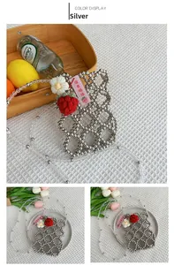 Detail of silver beaded mini crossbody bag with crochet flowers and strawberry charms