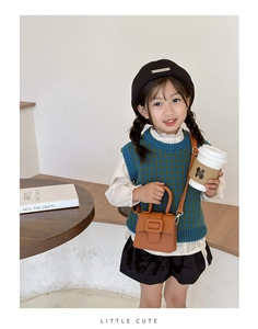 Toddler girl carrying a brown lychee pattern mini saddle bag with a top handle and strap
