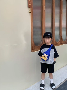 Close-up of kids street style outfit featuring blue bear crossbody bag with SMILE text