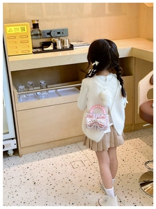 Dettaglio della borsa a tracolla in tweed per bambine con fiocco, perle e catena d'oro