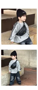 Gros plan d'un sac banane noir rétro pour enfant avec étiquette sport porté par un garçon