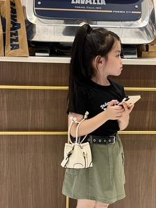 Mini white bucket bag with lychee grain texture and drawstring on a young girl