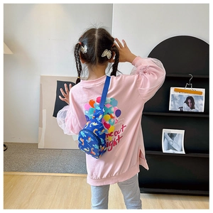 Blue dinosaur print kids chest bag worn by a child in a casual home setting