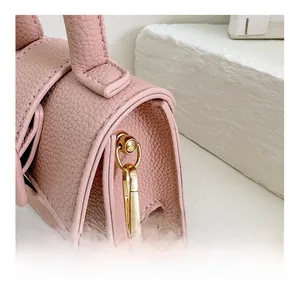 Detail view of pink litchi grain bag featuring detachable golden metal hook and stitching