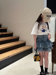 Detailed view of a yellow vintage mini handbag paired with a blue denim tiered skirt