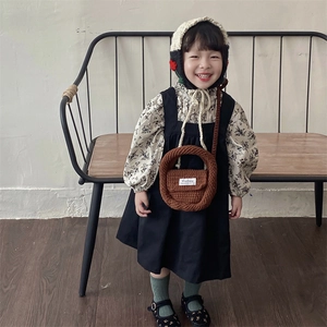 Retro autumn kids knit outfit with floral shirt, black dress and brown woven crossbody bag