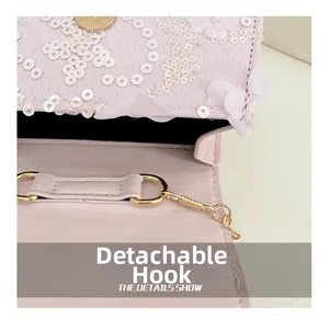 Détails d'un sac rose avec des crochets dorés amovibles et des motifs de fleurs à paillettes