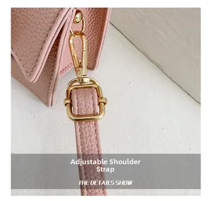 Close-up of adjustable strap with gold buckles on pink lychee leather kids saddle bag