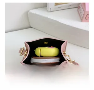Detail view of pink lychee leather saddle bag interior showing storage space and strap
