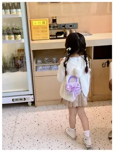 Fillette avec mini sac violet à motif pied-de-poule, nœud géant et poignée perle