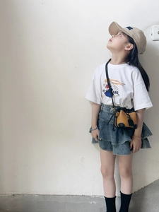 Detail of a brown drawstring crossbody bag paired with a casual outfit for kids