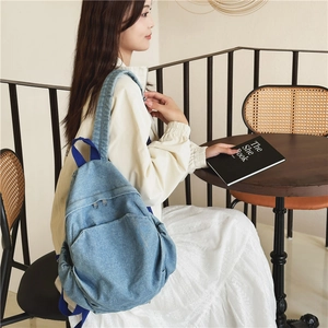 Simple light blue denim backpack for women featuring a spacious front zipper pocket