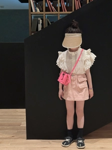 Detail of pink mini crossbody bag paired with kids stylish outfit and straw hat
