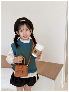 Close-up of kids vintage litchi pattern saddle bag with retro metal horseshoe buckle