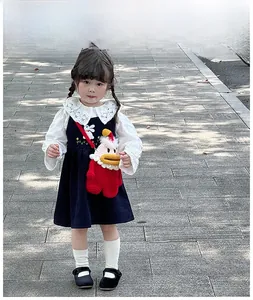 Détail robe fille en velours marine avec col dentelle et sac canard au crochet