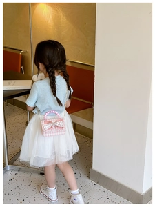 Dettaglio borsa a quadri rosa per bambina con fiocco in pizzo e manico di perle
